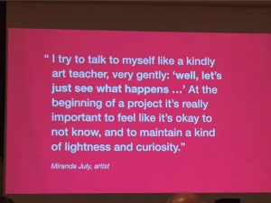 A red slide projected on the screen reads "I try to talk to myself like a kindly art teacher, very gently: 'well, let's just see what happens...' At the beginning of a project it's really important to feel like it's okay to not know, and to maintain a kind of lightness and curiosity." Miranda July, artist